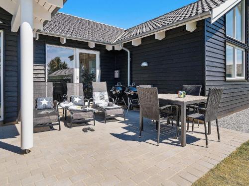 a patio with chairs and a table and a grill at 16 person holiday home in Hasselberg in Kappeln