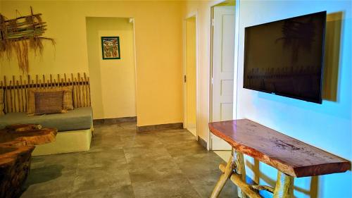 un soggiorno con una TV a schermo piatto su una parete di Villa Naicha a Sainte Marie