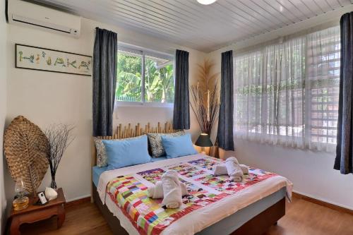 a bedroom with a bed with towels on it at Fare Nãhina - 2 Bedrooms - City Center - Swimming Pool in Papeete
