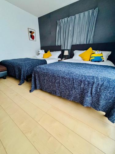 a bedroom with two beds with blue and yellow pillows at Nagomiの宿駅徒歩3分駐車場有梅田1駅1棟貸切4部屋京都神戸直通 in Osaka