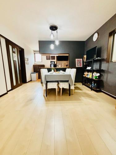 a living room with a table in the middle of it at Nagomiの宿駅徒歩3分駐車場有梅田1駅1棟貸切4部屋京都神戸直通 in Osaka