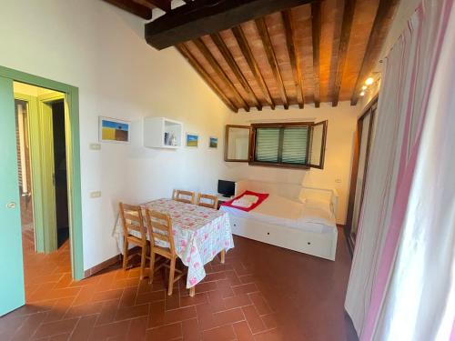 a bedroom with a bed and a table and chairs at Podere San Pietro in Le Case