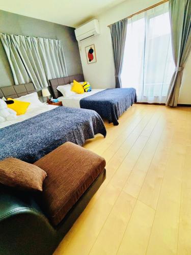 a hotel room with two beds and a large window at Nagomiの宿駅徒歩3分駐車場有梅田1駅1棟貸切4部屋京都神戸直通 in Osaka