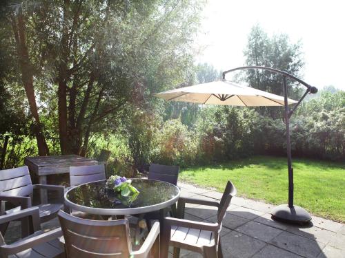 a table and chairs with an umbrella on a patio at Farmhouse appartment in Eede in Eede