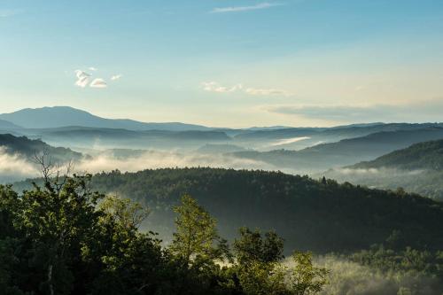 a view of a valley with fog and mountains at Mondellebotte - Luxus Villa & traumhafter Meerblick in Barat