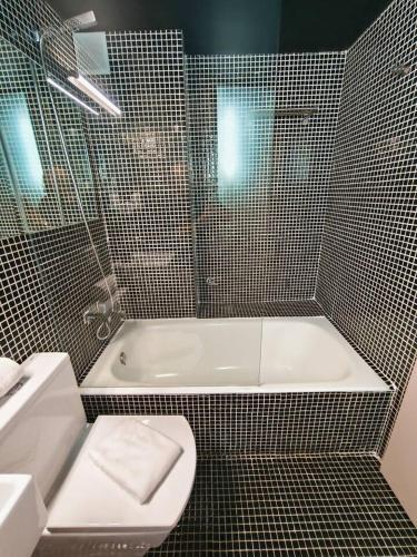 une salle de bain avec une baignoire, des toilettes et un lavabo dans l'établissement Apartamento Loft Desing City Center, à Tolède