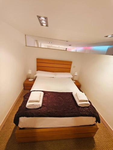 une chambre avec un grand lit avec deux serviettes dessus dans l'établissement Apartamento Loft Desing City Center, à Tolède