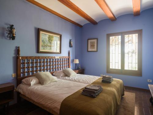 a bedroom with two beds with blue walls at Finca Fuente Laurel in Arucas