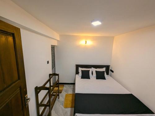 a small bedroom with a bed and a staircase at Willow Stay Ella in Ella