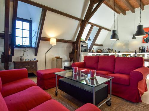 Una sala de estar con sofás rojos y una mesa. en Pool Escape in Saint-Laurent, en Saint-Laurent-la-Vallée