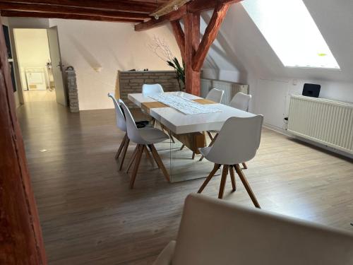 a dining room with a table and white chairs at Fewo am Fuße der Burg Stargard in Burg Stargard