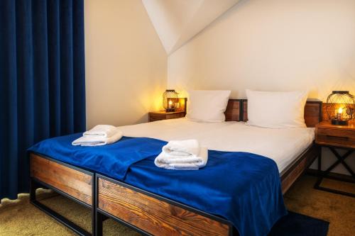 a bedroom with a bed with blue sheets and towels at Pawie Oczko in Tylice
