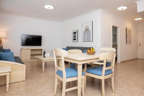 a dining room and living room with a table and chairs at Villamar Hotel in Morro del Jable