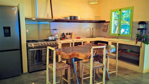 a kitchen with a wooden table and some chairs at Villa Naicha in Sainte Marie