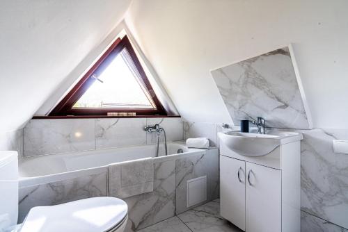 łazienka z umywalką, toaletą i oknem w obiekcie Apartamenty Tetmajera APARTZAKOP w Zakopanem