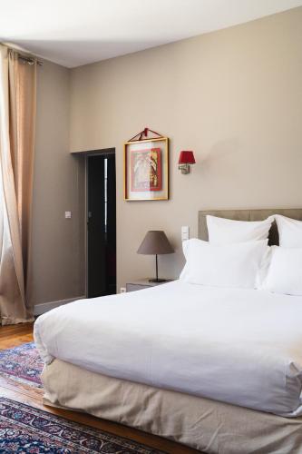 a bedroom with a large white bed and a window at Château de la Bousquetarie in Lempaut
