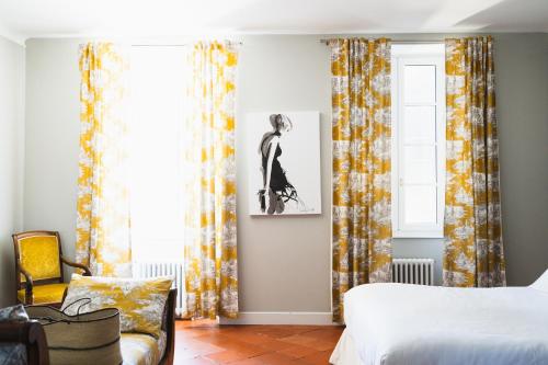 a bedroom with a bed and a window with curtains at Château de la Bousquetarie in Lempaut