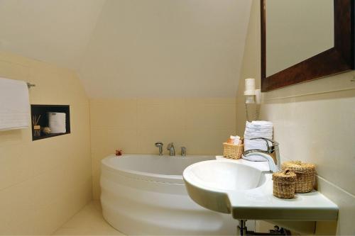 a bathroom with a white tub and a sink at Hotel Kazimierski Zdrój in Janowiec