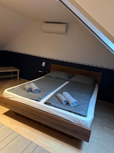 a bed with two pairs of towels on it at Heera Apartmans in Hajdúszoboszló
