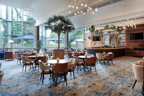 a restaurant with tables and chairs and a bar at Crowne Plaza London - Gatwick Airport by IHG in Crawley