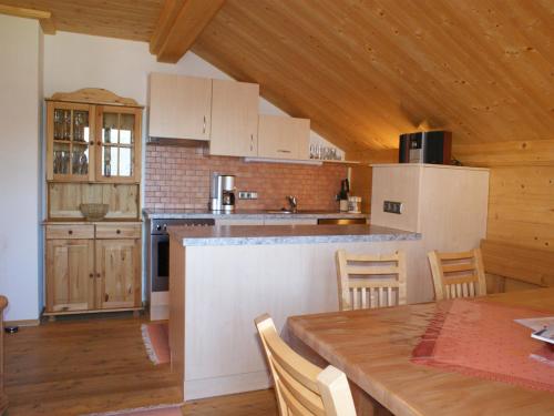a kitchen with white cabinets and a table with chairs at Chalet in Sankt Gallenkirch near Ski Bus in Sankt Gallenkirch