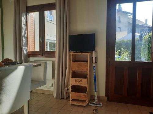 a room with a tv on a cart with boxes at Maisonnette au bord du Sierroz in Aix-les-Bains