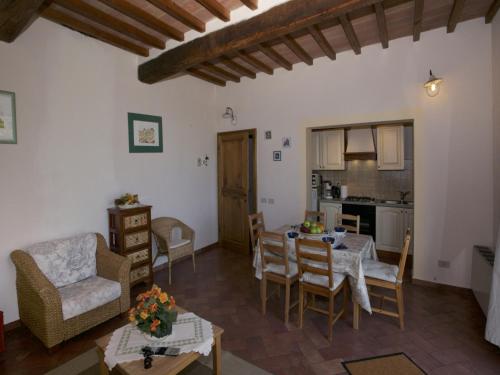 a kitchen and a living room with a table and chairs at Tuscan Hilltop Farm Stay in Castelnuovo Berardenga