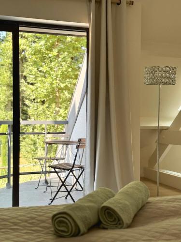 a bedroom with a bed with a view of a balcony at Villa d'architecte avec Piscine proche Paris in Rochefort-en-Yvelines
