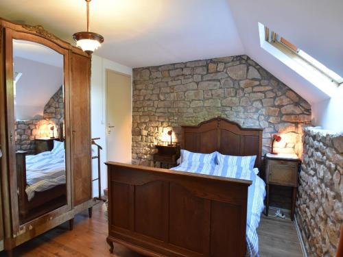 a bedroom with a stone wall with a bed and a mirror at Holiday Home in Saizy with Stargazing Garden in Vignol