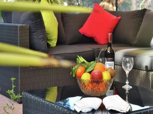 a bottle of wine and a bowl of fruit on a table at Chalet in El Toro with Pool by the Ocean in El Toro