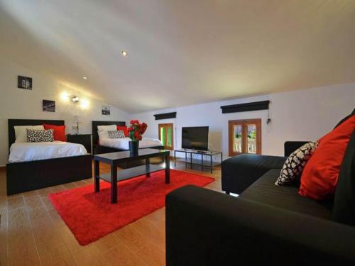 a living room with a bed and a couch at Chalet in El Toro with Pool by the Ocean in El Toro