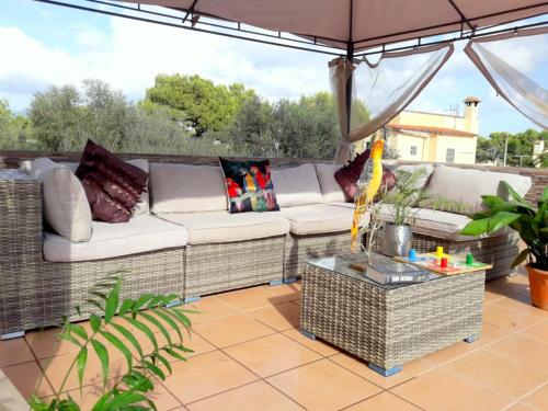 a patio with a couch and an umbrella at Chalet in El Toro with Pool by the Ocean in El Toro