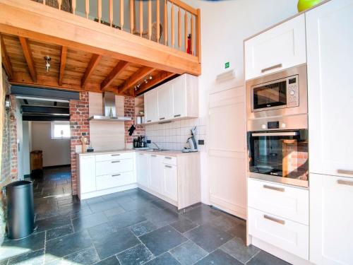 a kitchen with white cabinets and a tile floor at Liege Villa near Spa Circuit in Burnenville