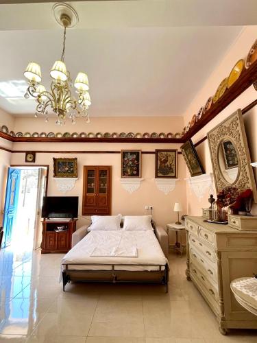 a bedroom with a bed and a dresser and a chandelier at Aeriko House Olympos Karpathos in Olympos