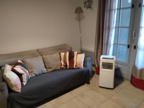 un soggiorno con un divano e una finestra di Spacieux appartement tout confort proche plage et centre ville Wifi Animaux bienvenus a Saintes-Maries-de-la-Mer