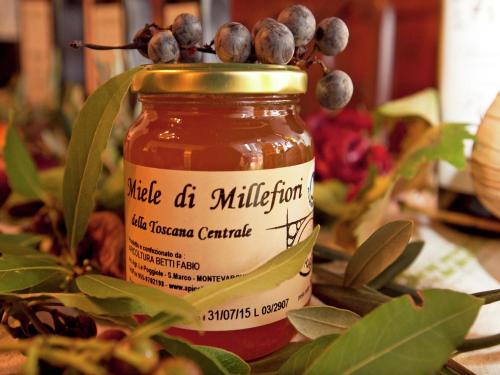 a jar of honey with a bunch of berries on it at Apartment Tuscany near Pratomagno Mountain in Pian di Scò