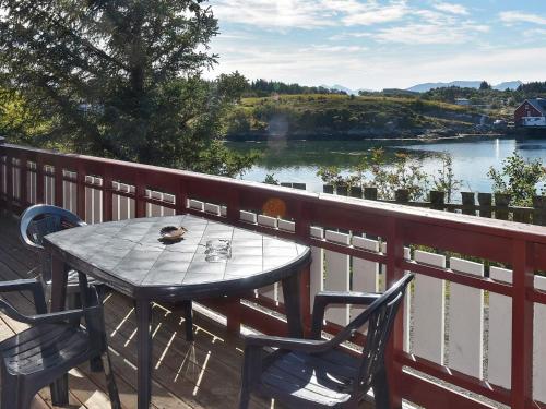 a table and chairs on a balcony with a view of a river at 6 person holiday home in Bud-By Traum in Bud