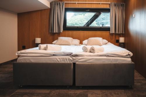 a large bed in a room with a window at NOI Resort SPA - woda i las in Tęgoborze