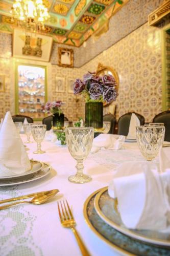 a table with plates and silverware on a white table cloth at Dar KORAICH in Kairouan