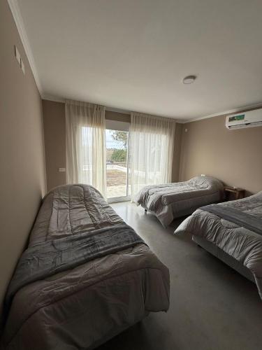 a bedroom with two beds and a window at Hotel BIOCERRO in Tandil