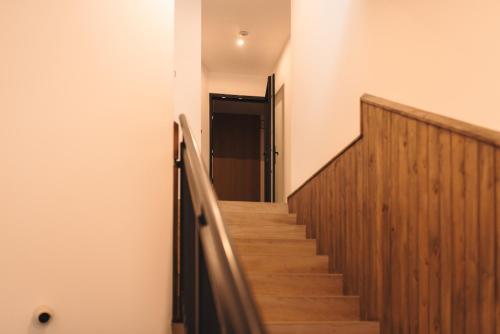 a hallway with a wooden staircase with a door at NOI Resort SPA - woda i las in Tęgoborze