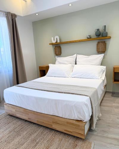 a bedroom with a large bed with white sheets at Calèma Apartments in Villasimius