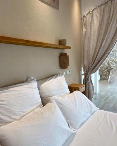 a bed with white sheets and pillows in a bedroom at Calèma Apartments in Villasimius