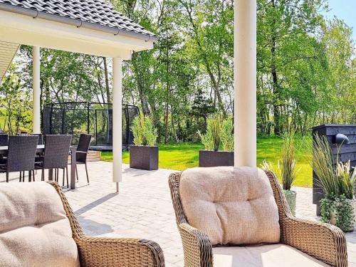 a patio with wicker chairs and a gazebo at 14 person holiday home in Væggerløse in Marielyst