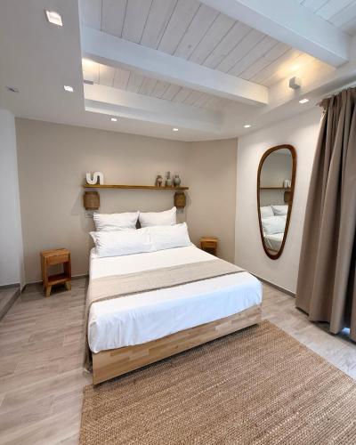 a bedroom with a large bed with a large mirror at Calèma Apartments in Villasimius