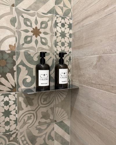 two bottles of wine sitting on a shelf in a bathroom at Calèma Apartments in Villasimius
