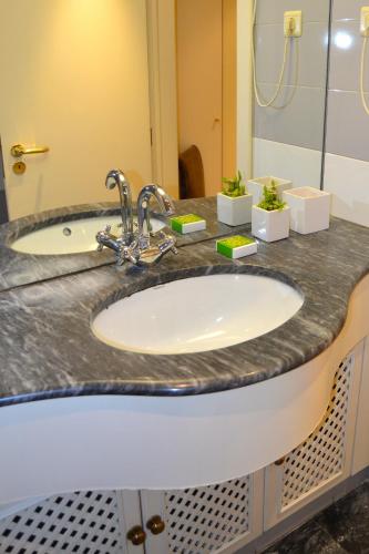 a bathroom counter with a sink and a mirror at All in One City Flat - Pool, parking & nomad in Lisbon