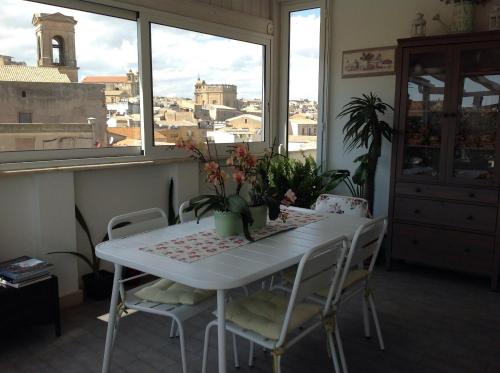 a white table and chairs in a room with a window at Attico Da Rosa con vista spettacolare a 360 gradi in Caltagirone