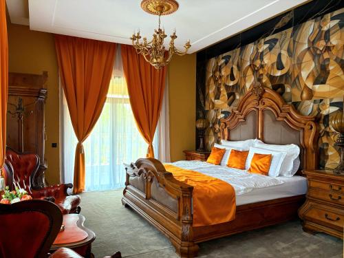 a bedroom with a large wooden bed with orange pillows at La Casa Boutique in Kostinbrod