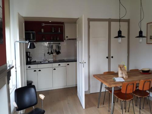 a kitchen with a table and chairs in a room at Holiday Home Zoutkamp near Lauwersmeer in Zoutkamp